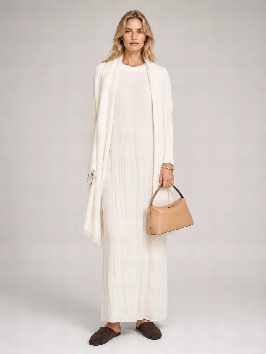 A whisper-light Totême column in soft ivory is grounded with rich chocolate suede mules for a cocooning, quietly luxurious ritual mood. A structured camel-nude baguette and a slim gold cuff introduce just enough structure and shine, while an airy ivory stole keeps everything soft and serene. The result is loungewear that feels intentional, made for slow mornings that might drift gently into the outside world.