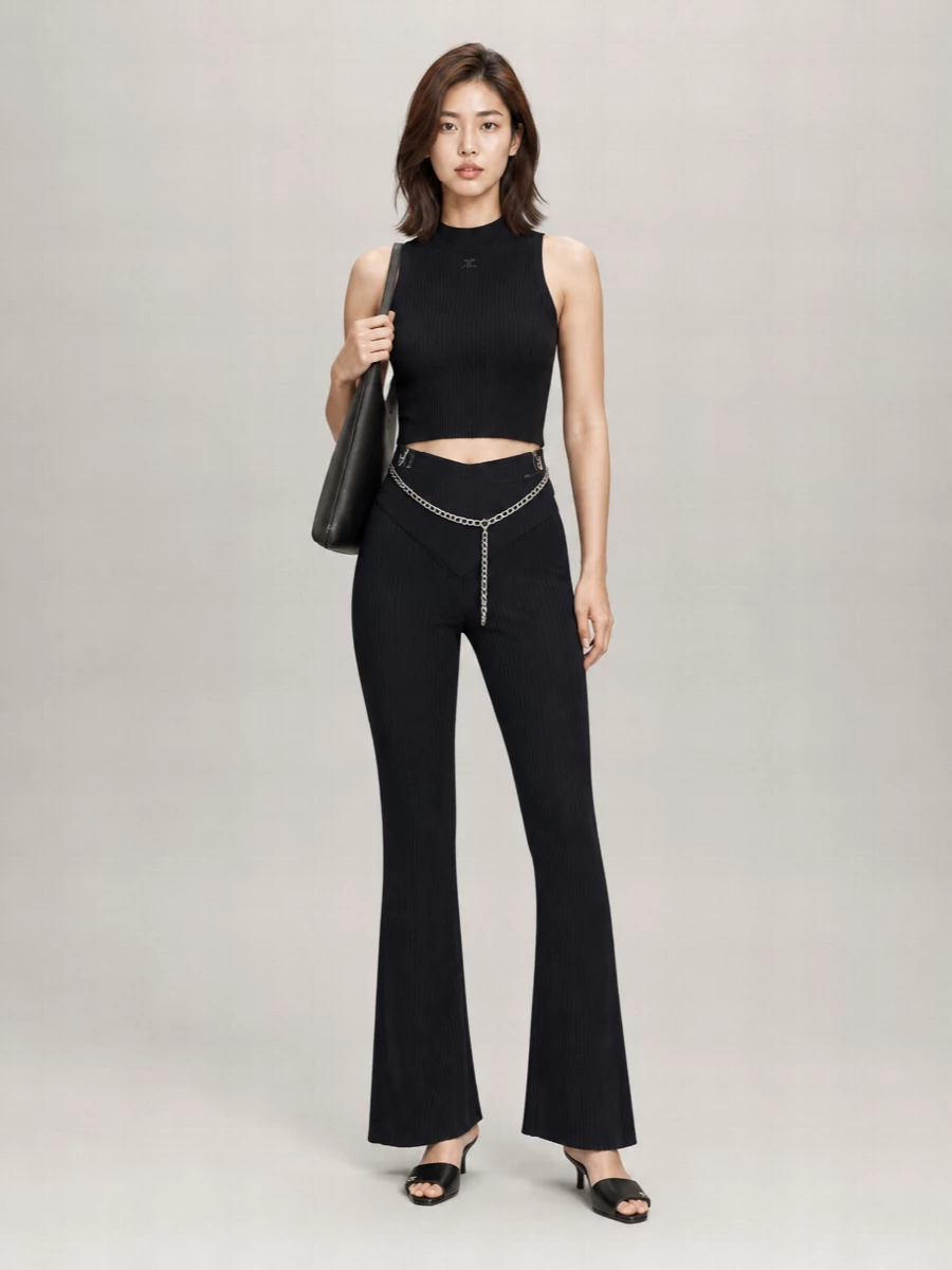 Deep navy rib and inky black knit sit together in a clean, elongated silhouette that feels unapologetically Courrèges. The pointed high waist and cropped mock neck carve a long, lean line, while low kitten mules and a slim shoulder bag keep everything sharp but easy. A silver chain at the waist adds just enough shine to take this from late-afternoon gallery visits straight into night.
