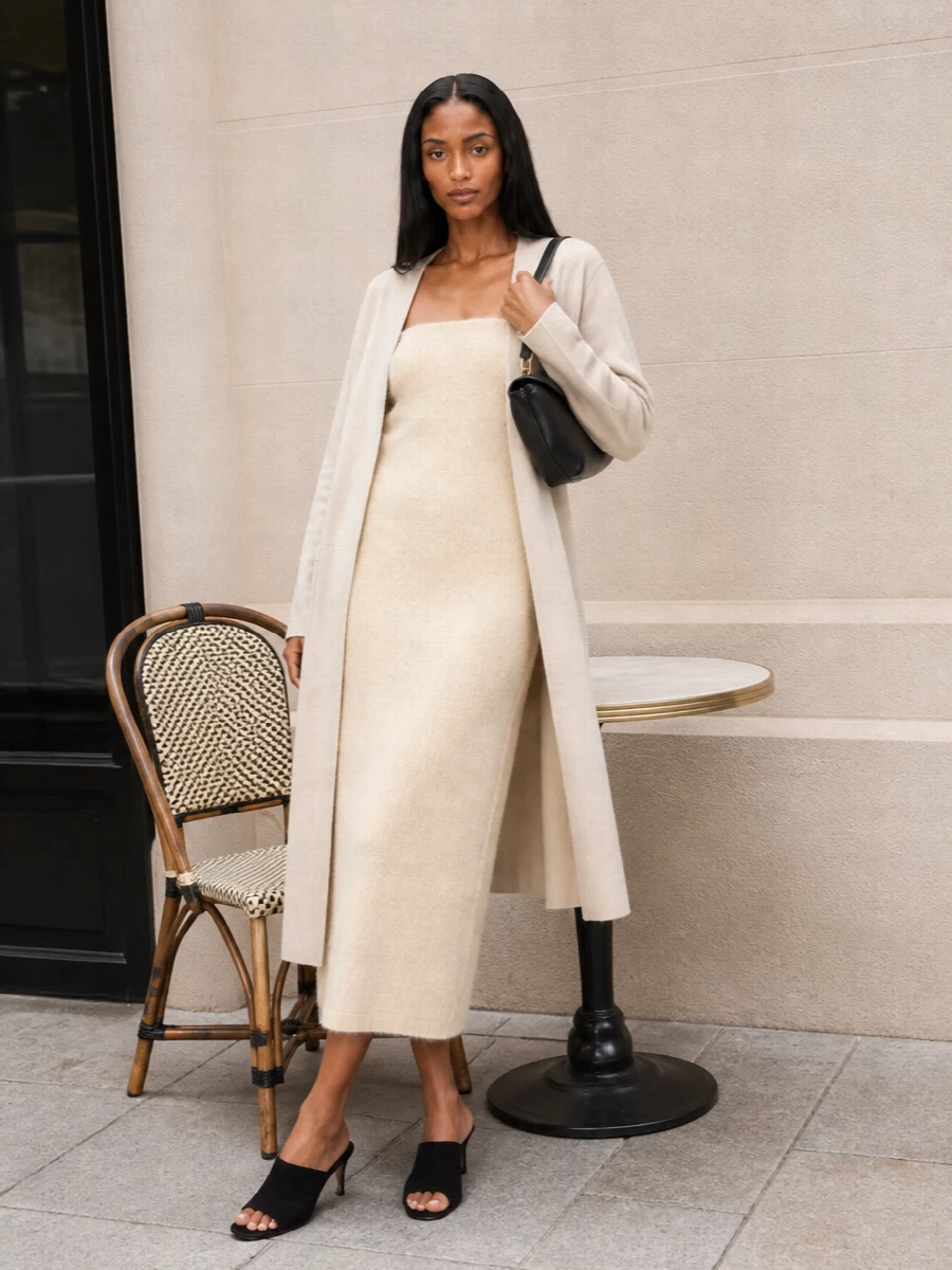 I’m styling this as a pure evening column: the fuzzy strapless Totême dress under the clean, collarless coat keeps the silhouette long, calm, and quietly sensual. Black suede mules and a structured black shoulder bag sharpen the softness, giving you a precise contrast that still feels minimal and grown up. Skim the coat open so the texture of the knit and the line of the dress read as one continuous column under the neutral shell.