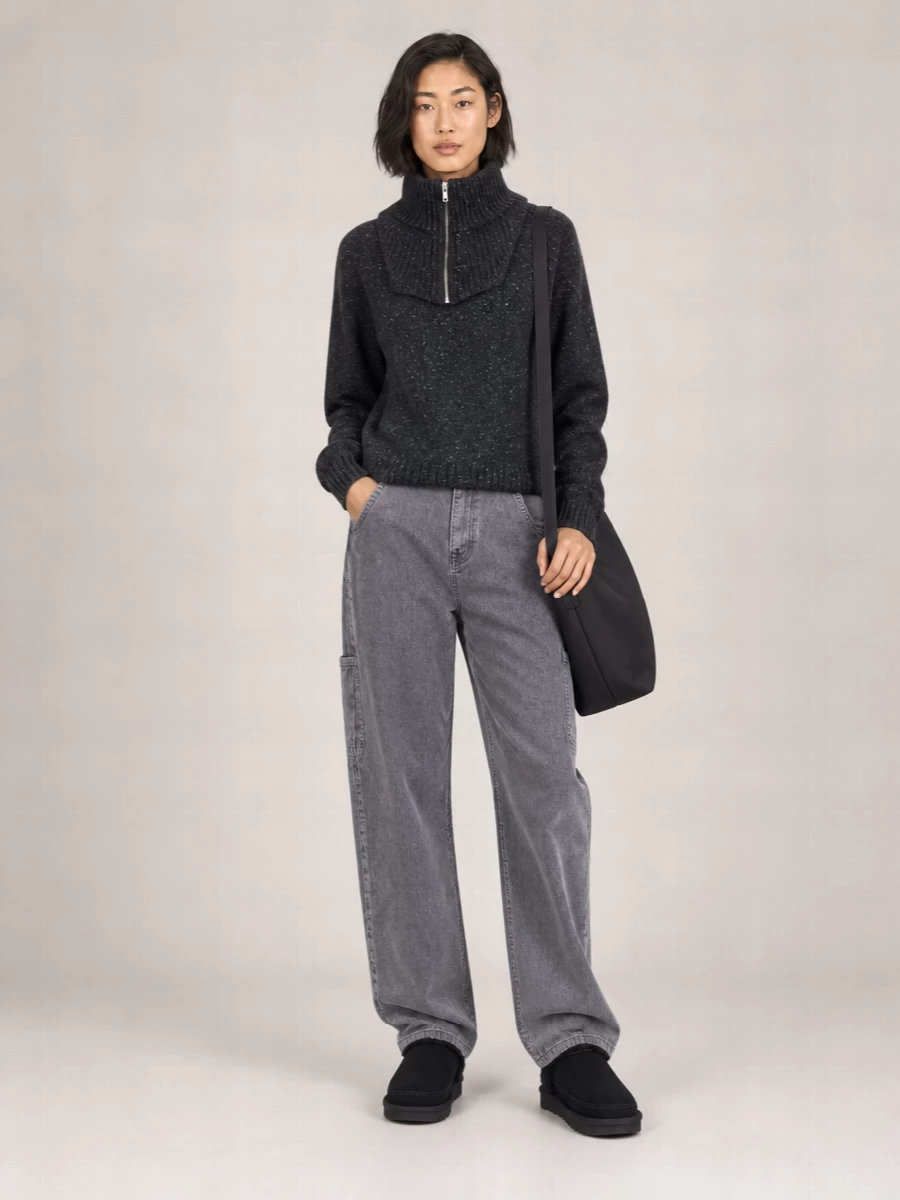 Anchor the asymmetric high-neck knit with washed-grey cargo denim for a monochrome, city-ready uniform that still feels quietly relaxed. Chunky black suede boots and an oversized Margiela shoulder bag keep the mood practical and grounded, while the zipped tube scarf subtly sharpens the whole composition.