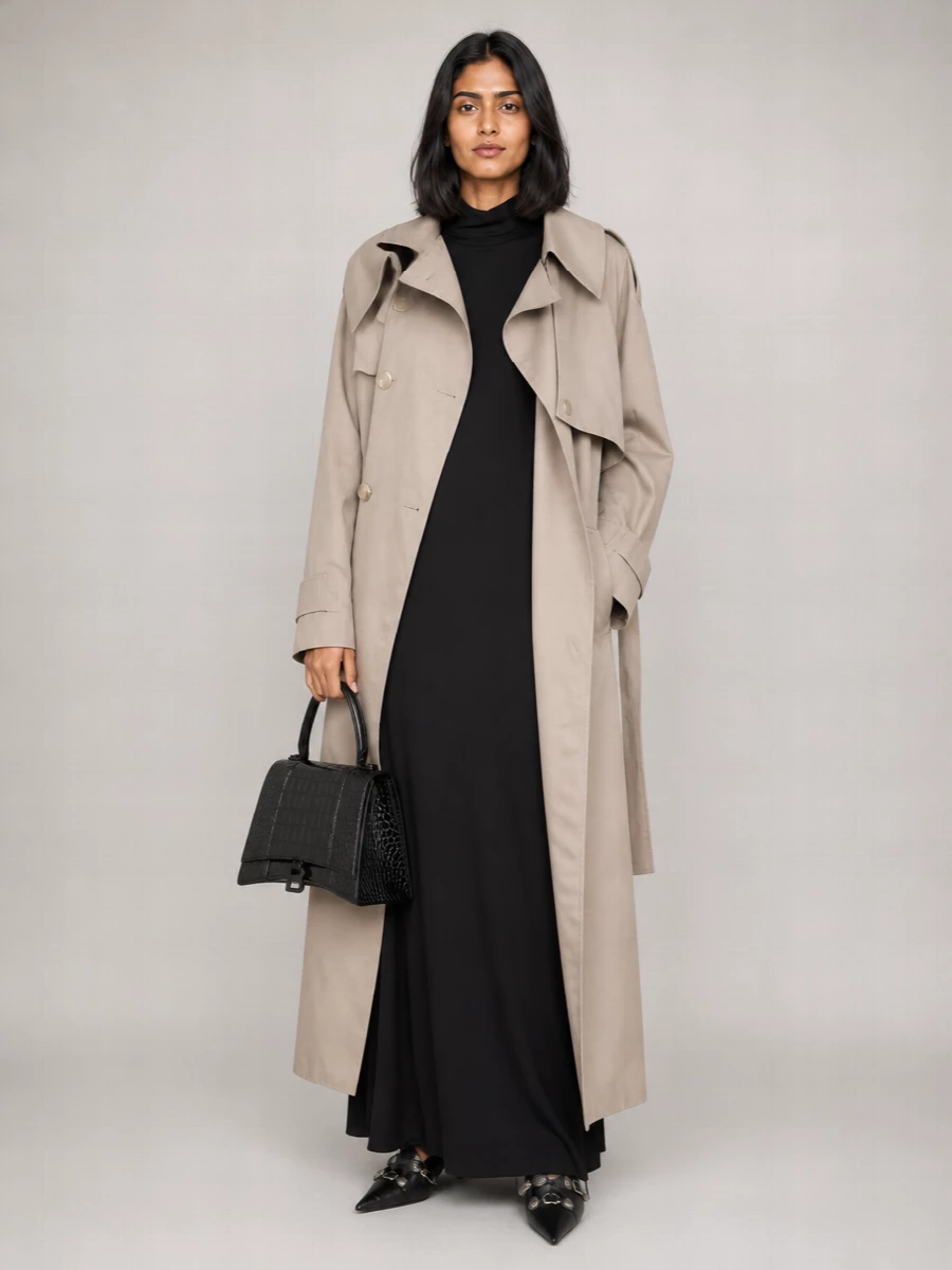 I’m styling the trench as a dramatic outer layer over a floor-length black column dress, so the lines stay long, clean and unmistakably modern. The pointed pumps and sculpted croc bag keep everything in the same high-gloss, quiet-luxury register while the hardware subtly talks to the coat’s buttons. It is gallery opening to late dinner, with the trench shrugged on or off without ever diluting the silhouette.