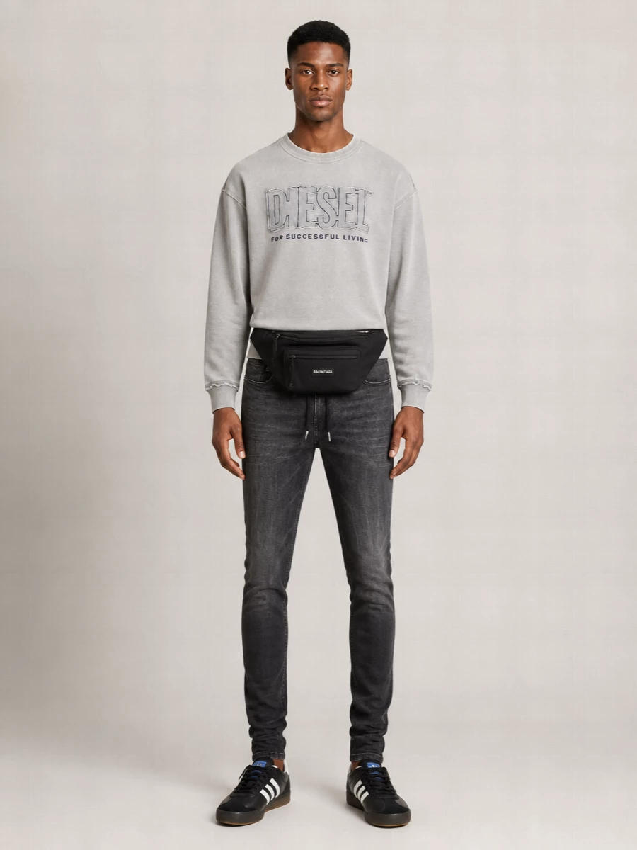 Washed charcoal tones run head to toe, pushing the jogger-style skinny denim into a sharper street mood with the logo sweatshirt and slim retro trainers. The result is a tight, graphic off-duty uniform that feels considered but still easy for city days and low-key nights. Monochrome textures do the work, so the only thing you have to think about is how hard you want to lean into the attitude.