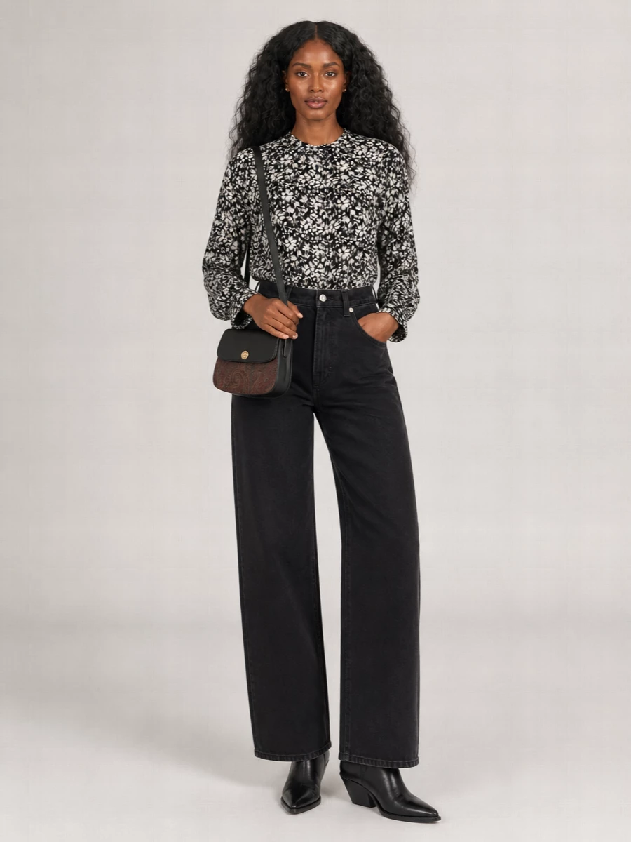 A monochrome floral blouse meets washed black wide-leg denim for a romantic, Left Bank take on everyday dressing. Sleek black western boots keep the line long and confident, while a compact paisley-trim crossbody adds just enough quiet character at the hip.