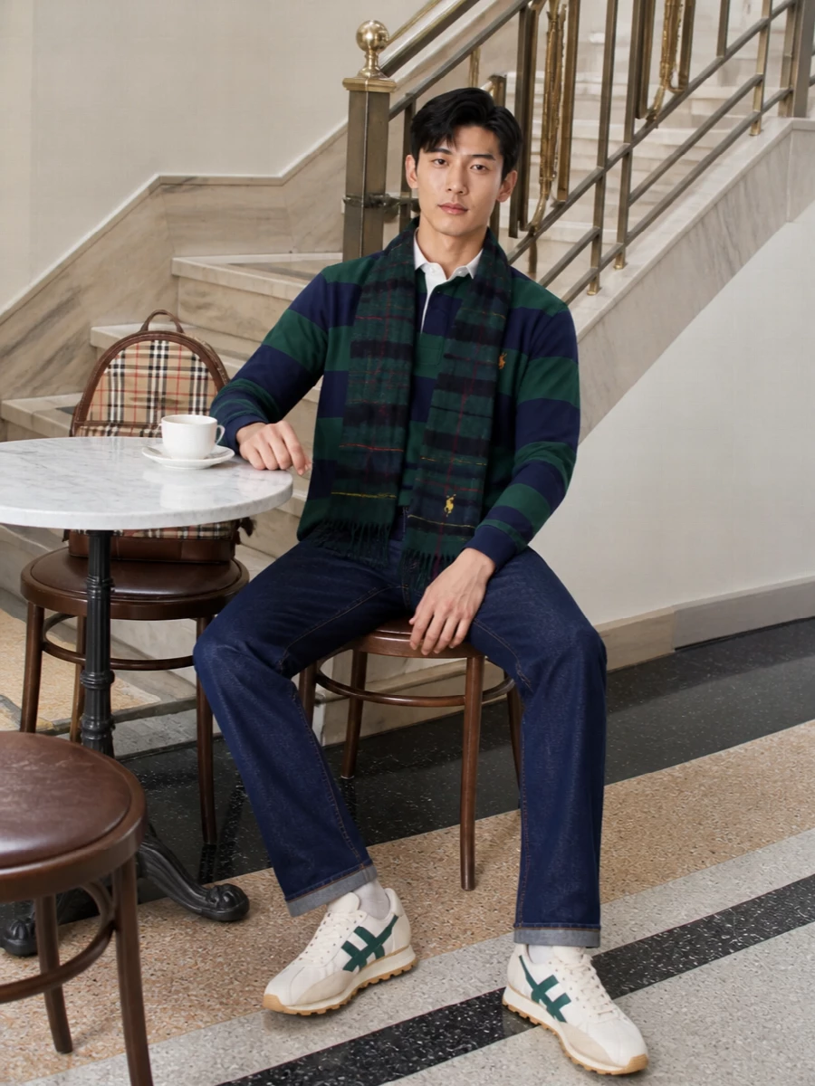 A striped rugby polo, dark indigo denim and retro runners set a sharp, collegiate weekend mood that still feels easy. Forest green accents in the sneakers and scarf quietly echo the top, while the Burberry check backpack adds a single heritage nod that keeps everything feeling considered rather than matchy-matchy.