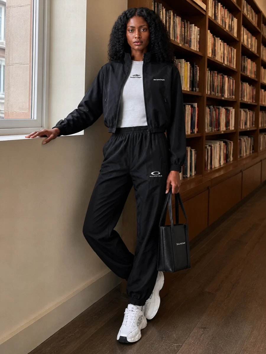 This is a sharp, monochrome Balenciaga street set built around a cropped bomber and a clean, slightly technical base layer. I chose the top and track pant route instead of a dress so the bomber can stay the star, and the proportions of cropped knit, relaxed pant and chunky runner keep the silhouette athletic but considered for city days. The structured mini tote tightens the whole story, giving logo cohesion without tipping it into full branding overload.