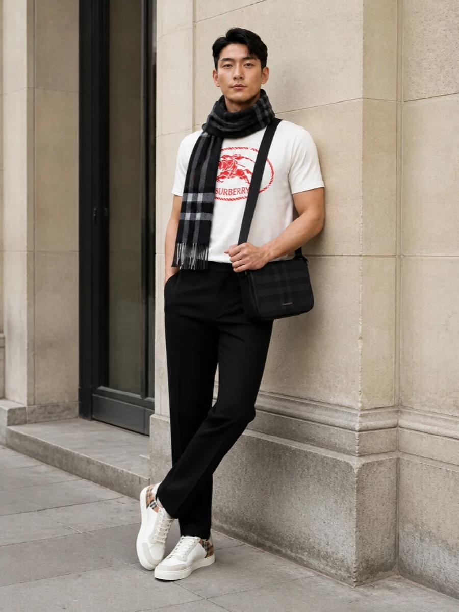 This look centres the off‑white Burberry crest tee against sharp black straight-leg chinos for a clean, modern take on preppy streetwear. Off‑white court sneakers with a discreet check heel and a tonal black crossbody keep the palette tight and elevated, while a charcoal checked scarf adds quiet winter polish without stealing focus from the bold red graphic.