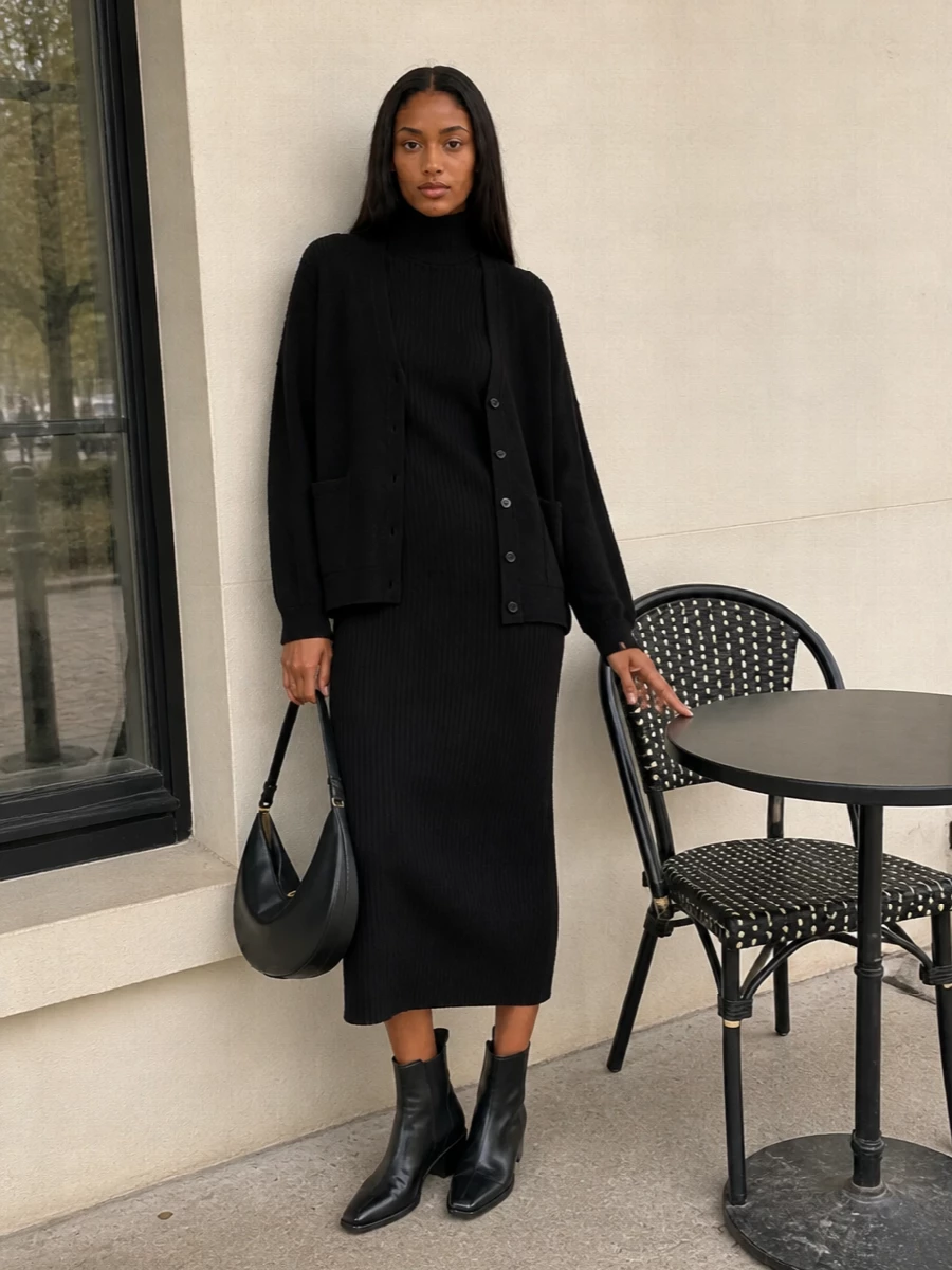 I am building this around the dress rather than a top and bottom, because a single black knit column under the cardigan jacket feels more intentional and aligned with the quiet luxury brief than doubling cardigans or adding lounge-leaning knit pants. The black A.P.C. turtleneck dress, Extreme Cashmere cardigan jacket, sharp Aeyde Chelsea boots and sculptural Jacquemus bag read as a unified, city-ready knit uniform with just enough structure to move from office to dinner. The all‑black palette keeps the focus on texture and proportion, so the relaxed jacket against the straight dress line feels modern rather than severe.