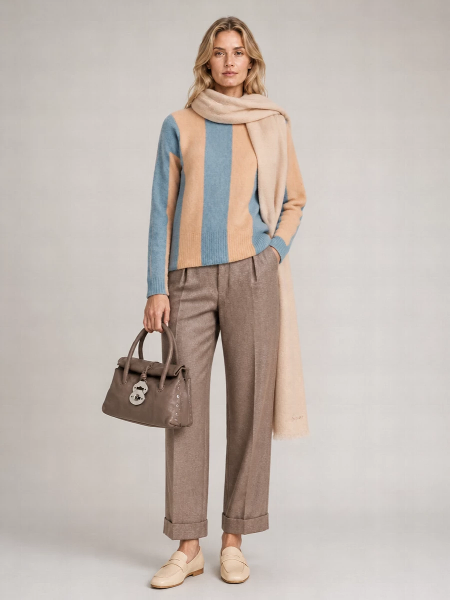 Soft vertical colour blocking meets grounded taupe tailoring for a relaxed, quietly polished day ensemble. Butter-beige loafers and a structured taupe bag keep the palette calm and refined, letting the knit supply the gentle colour. A blush scarf subtly echoes the apricot stripe, pulling the whole outfit into a cohesive, modern neutral story.