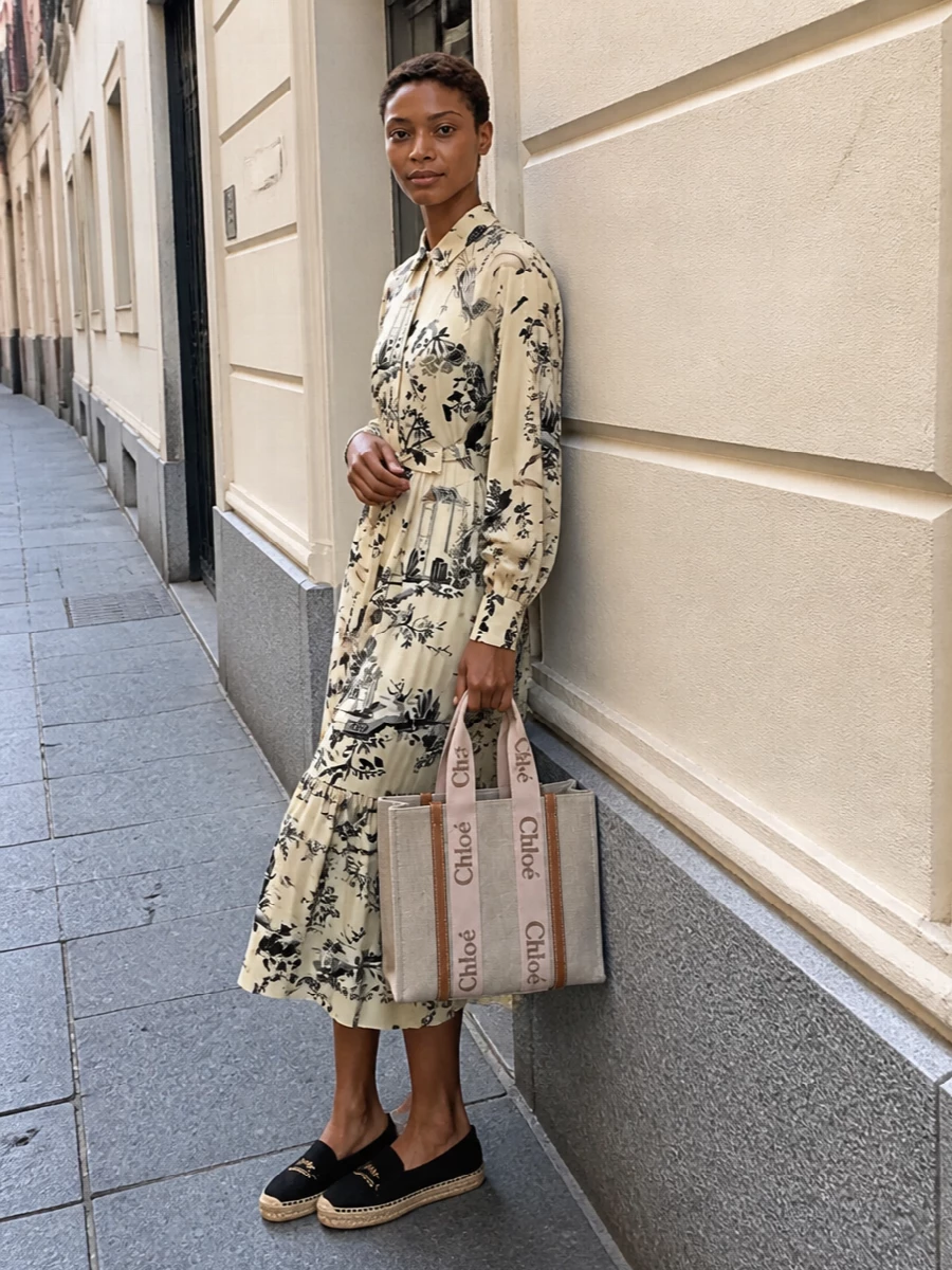 A softly printed Etro shirt dress plays to the Chloé tote’s natural canvas and warm leather, giving an easy, boho-leaning take on city polish. Saint Laurent’s espadrilles keep it grounded and relaxed, while the black canvas adds just enough contrast to sharpen all those soft neutrals. Choosing the dress route here keeps the silhouette fluid and uncomplicated, which better suits the tote’s easy, carry-everywhere spirit than a more constructed top and trouser pairing would.