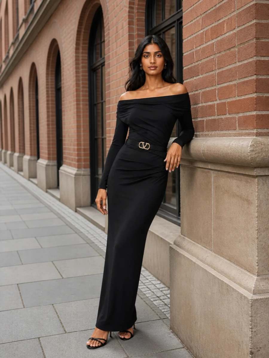 A sharply cut black column gown is paired with fine-strapped heels and a structured clutch for a pure, streamlined evening statement. Discreet pearls and a crystal buckle concentrate all the shine at the face and waist, keeping the silhouette long, modern and quietly decisive.