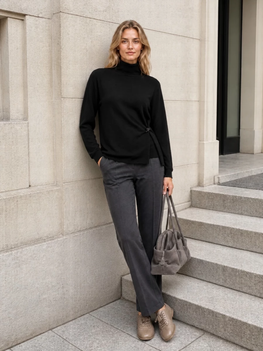 A relaxed black mock neck meets fluid charcoal tailoring for a soft, monochrome column that feels calm and intentional. Taupe-grey accessories gently warm the palette, keeping everything understated yet city ready. The result is loungewear-level comfort with just enough structure to move through a full winter day.