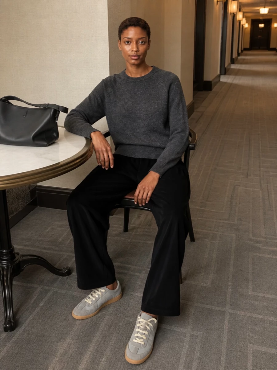 Charcoal on black keeps this combination calm and directional, with the raglan knit softening the line of the structured wide-leg trouser. Grey sneakers echo the tones while staying refined, and a sculpted black shoulder bag sharpens the whole silhouette for city days that move quietly from morning to night.