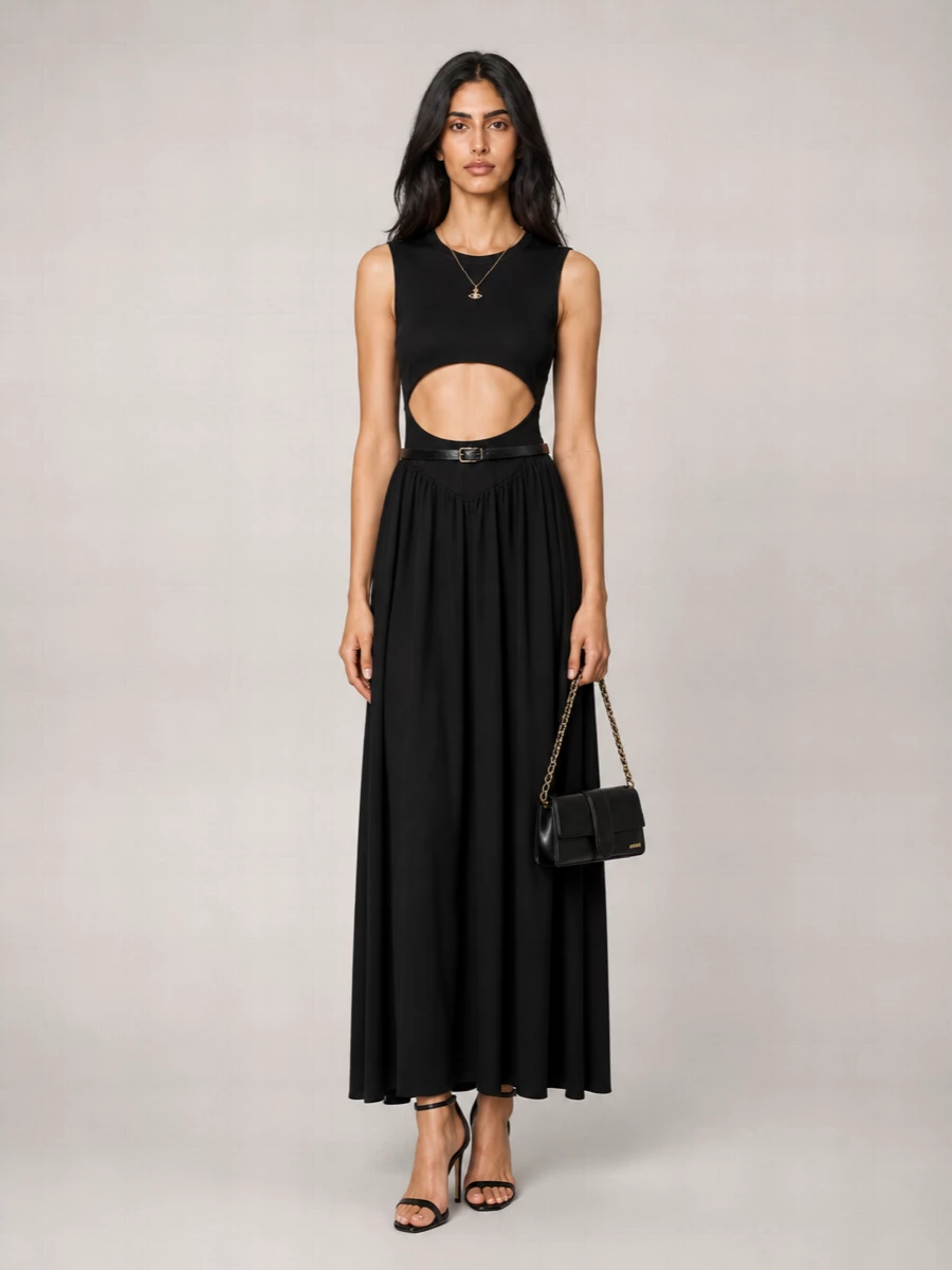 A sharply sensual black column with cut-out detailing is framed by a bare, high stiletto and a slim baguette under the arm, keeping everything graphic and clean. Fine gold and crystal at the collarbone plus a narrow belt at the waist add just enough definition and light without interrupting the fluid movement of the skirt.