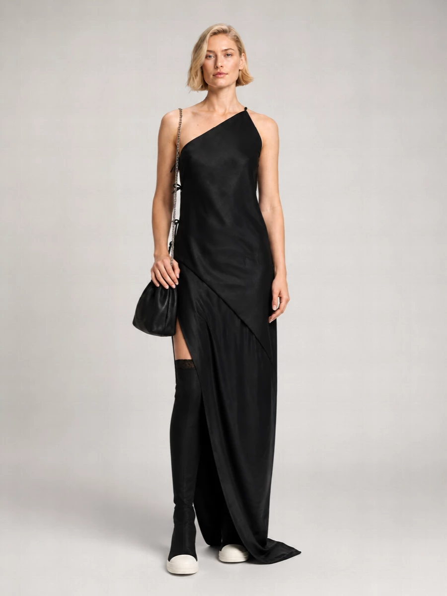 A stark black column grounded with over-the-knee sneaker boots leans into Rick’s downtown drama while staying minimal and sharp. A compact, chain-hung pouch and discreet silver studs keep everything close to the body, so the asymmetric neckline and trailing hem stay the focus. The result reads like night-out streetwear, severe but very wearable once you are moving in it.