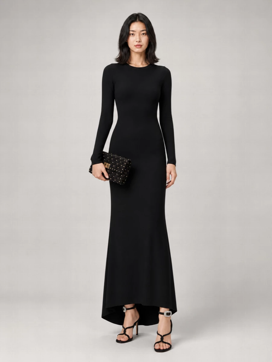 The Gucci gown and Valentino clutch create a pure black-tie moment, all clean lines and subtle drama, with the gold studs acting as the only hard gleam against liquid black. Gianvito Rossi’s strappy sandals keep that vertical, uninterrupted line, adding just enough sparkle at the ankle for movement without breaking the quiet-luxury mood. Choosing the dress route over separates keeps the story minimal and assured, letting fabric, cut and a few precise metal details do all the work.