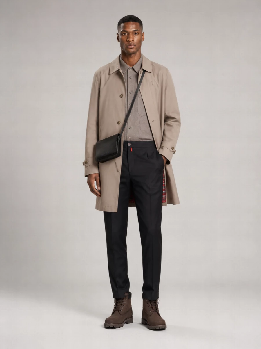 A stone Baracuta mac sits over tonal taupe and deep charcoal, giving a quiet, city-ready take on modern prep. Tailored Kiton trousers and dark Timberland boots keep the line sharp, while the slim Marni crossbody adds just enough structure without breaking the minimalist mood.