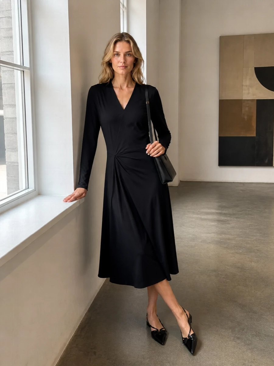 I chose the draped black midi dress path to echo the bag’s slim, minimal lines and keep the outfit focused and quietly polished. The wrap detailing and fluid cut introduce just enough movement, while the pointed patent flats keep the mood refined rather than overtly evening. Together they create an understated black-on-black composition where texture and cut, not logos, do the talking.