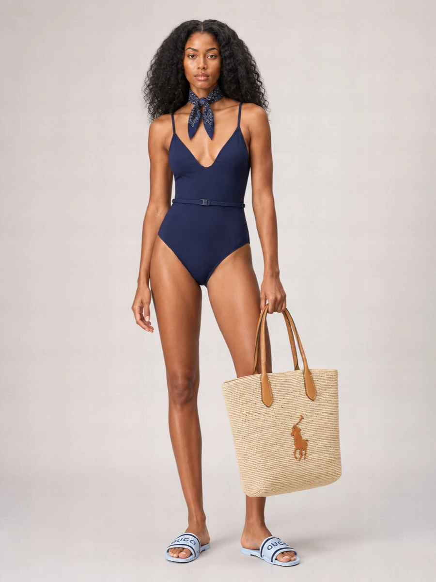 Navy-on-navy keeps this swim ensemble crisp and composed, letting subtle texture and clean lines do the work. Sporty striped slides and a structured straw tote lean into Riviera-preppy ease, while a small navy scarf adds just enough polish without feeling fussy. The result is relaxed, brand-conscious and ready for both lounger and beach bar stool.