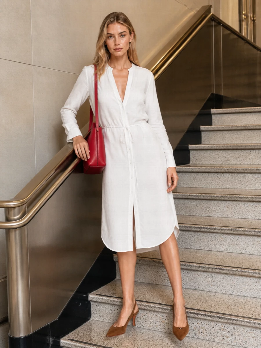 The Margiela shirt dress route is the strongest anchor here, creating a crisp white canvas that lets the raspberry Tod’s tote read as deliberate color rather than one more accent. The long, relaxed tie-waist silhouette keeps the mood understated and modern, while the camel Santoni slingbacks add height and polish in a neutral that bridges the bag’s warmth without shouting. It is an easy city outfit that feels considered from coffee meetings to dinner, grounded in quiet luxury with just one confident flash of red.