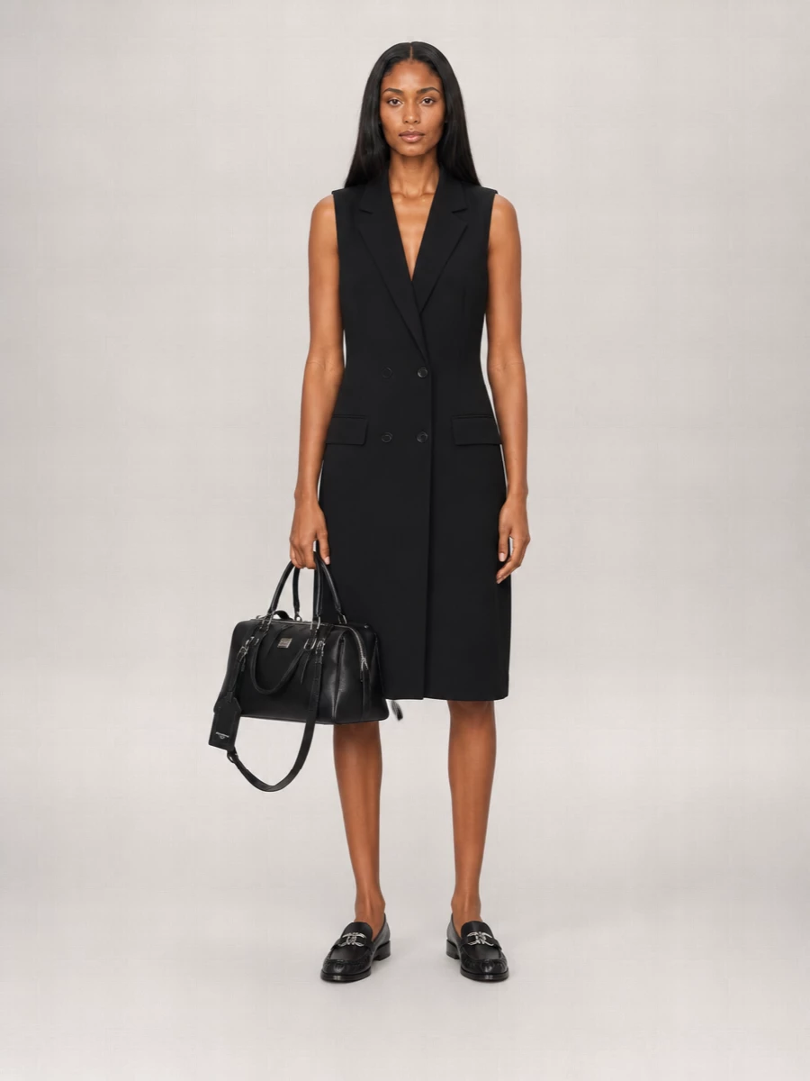 This is a boardroom-to-bar uniform built around sharp tailoring and a hushed black palette. The Balenciaga blazer-dress creates a precise vertical line that lets the Dolce & Gabbana bag read as a deliberate, structured accent. Ferragamo’s silver-detailed loafers ground the outfit with Italian polish and all-day practicality, keeping the whole composition quietly powerful rather than overtly formal.

I chose the dress route here because a tailored blazer-dress delivers the same authority as a suit, but with less visual noise around the strong, structured bag, and it transitions more fluidly into evening than a shirt-and-trouser combination.