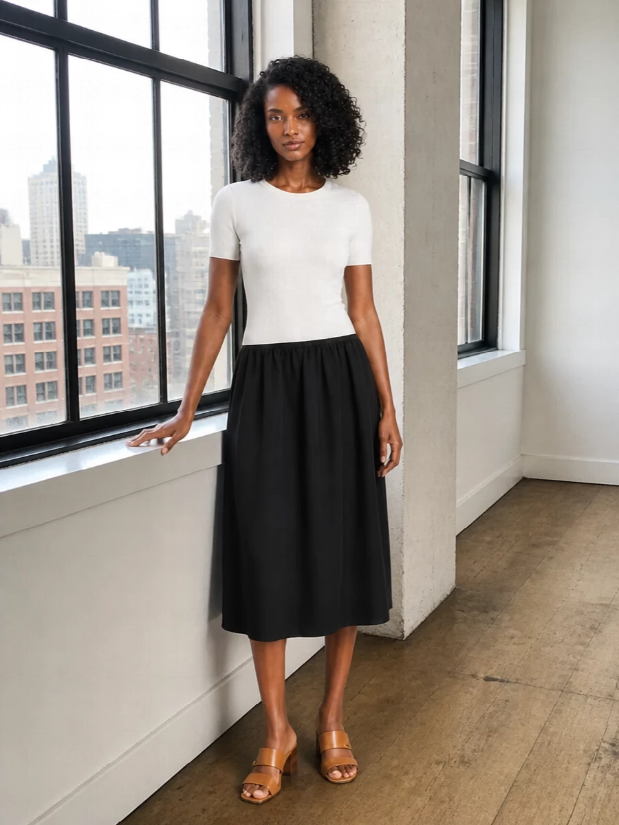 A black-and-ivory Totême midi pairs with the cognac MCM tote for a streamlined, modern city ensemble that feels quietly luxurious rather than logo-led. The clean two-tone column lets the structured monogram bag take focus, while tan block-heel sandals subtly pick up the warm leather tones. Choosing the dress route keeps the outfit sharp and uncomplicated, ideal for days when you want one decisive piece to carry you from meetings to dinner.