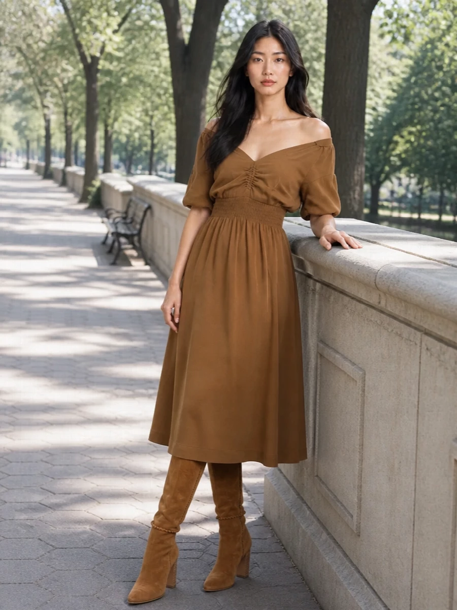 A camel-on-camel story keeps the Gucci bag firmly in focus, pairing it with a softly sculpted Miu Miu off-shoulder midi that feels polished without being loud. The warm, tonal palette and fluid lines read quietly luxurious, while the suede knee boot grounds everything in a modern, city-ready way. Choosing the dress path rather than tailoring keeps the silhouette clean and sensual, letting the bag’s heritage stripe provide the only graphic note.