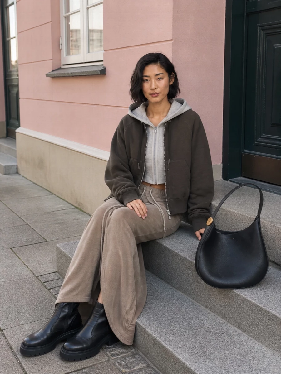 I’m building around separates rather than a dress so the Sacai hoodie reads as a true outer layer over a cropped Rick sweatshirt and floor-length Rick jersey skirt, all in the same taupe-charcoal register. The long, slit maxi and chunky black boots give you a sharp vertical line, while the oversized Coperni hobo keeps the whole thing practical for real city movement. It is a quiet, technical street set you can actually live in through the colder months without losing the designer attitude.