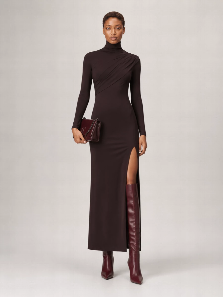 I’m anchoring this with the dress route rather than separates, because the sculpted chocolate maxi creates a cleaner, uninterrupted line with the burgundy knee boot. The result is a pared-back evening column in deep brown and wine, where the thigh slit and pointed stiletto keep the mood confident but still very quiet. A small oxblood chain bag sharpens the palette and adds just enough polish without disturbing the minimalism.