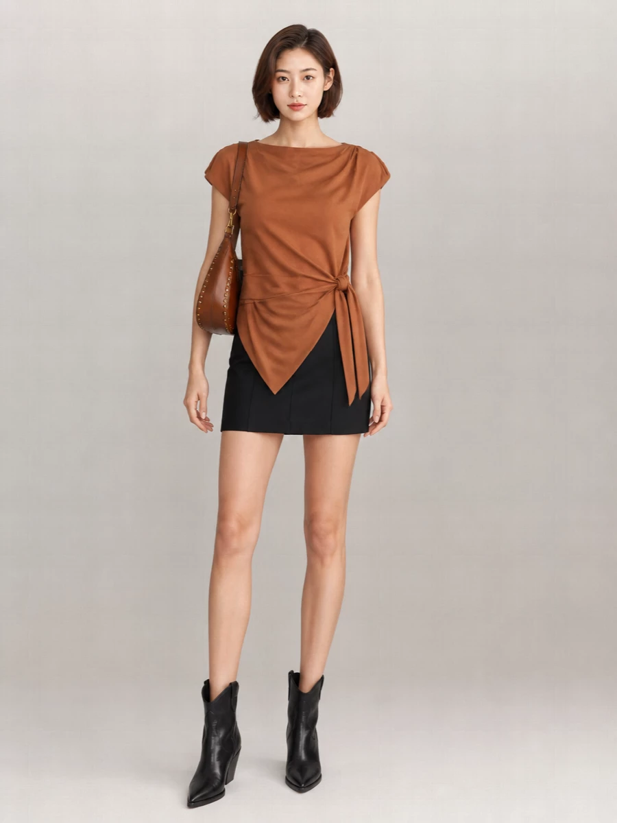 Caramel and black meet in a sharp, leggy mix that feels easy for late drinks yet considered enough for an opening night. The sculpted shoulders and cinched waist stay in focus against the clean black mini and boots, while the cognac bag softens everything with a warm, bohemian accent. It is relaxed but intentional, with just enough western edge to keep the minimal lines interesting.