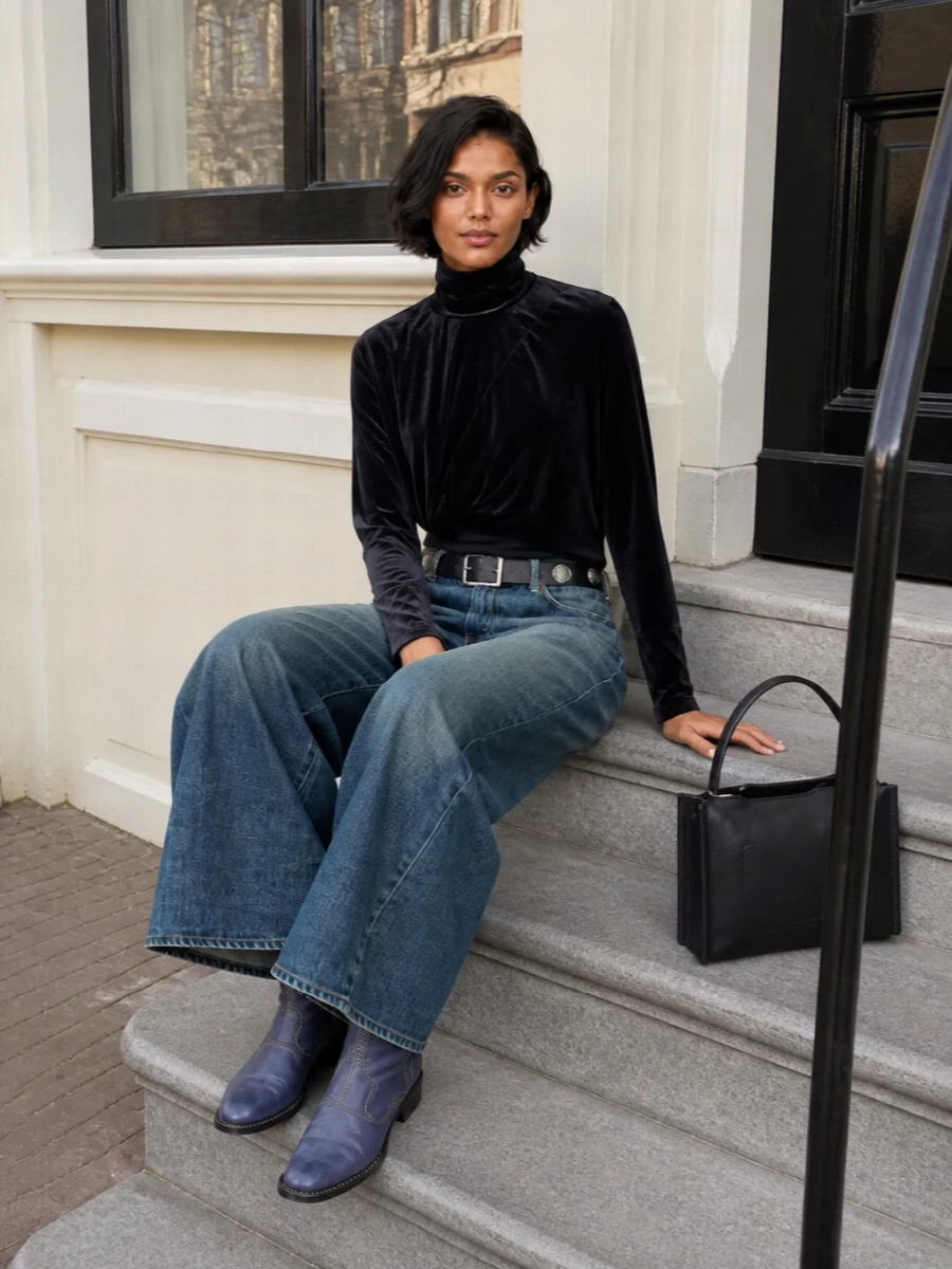 Mid‑indigo wide‑leg Junya denim meets an inky velvet turtleneck for a dark, sculptural take on streetwear tailoring. Ink‑blue Guidi boots and an inky navy top‑handle keep the palette hushed and directional, while a slim studded belt crisps up the mid‑rise and anchors the volume. The result feels architectural yet relaxed, ideal for city days that stretch well into night.