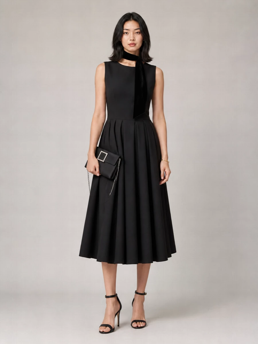 A deep black Magda Butrym midi dress is paired with barely there Prada heels and a crystal framed Roger Vivier clutch for a polished, evening ready balance of structure and ease. A single Margiela cuff and a slim velvet scarf keep the styling deliberate and quiet, so the pleated A line silhouette does all the talking. The result is a modern cocktail ensemble that reads feminine, sculpted and confidently understated.