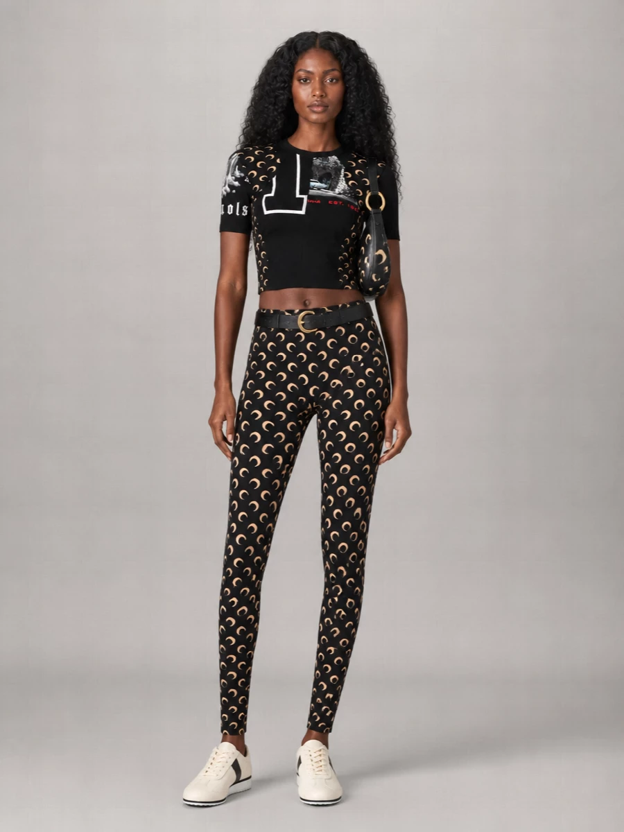 Head-to-toe Marine Serre moons turn this into a graphic city uniform, with the cropped tee and second-skin leggings reading like a single, sculpted base layer. Cream-and-black runners and the crescent shoulder bag keep it grounded and practical, while the gold hardware and belt add just enough shine for night rides and late bars. It is streamlined, athletic and unapologetically branded, built for moving fast through the city without losing the attitude.