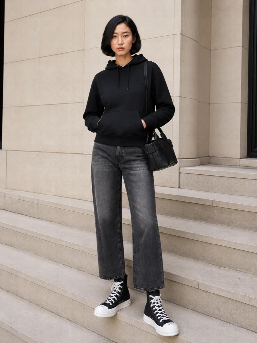 Grounded in the DRKSHDW-style high-top, this outfit leans into a tight black and charcoal story for a graphic, minimalist street mood. The Courrèges hoodie and Haikure straight jeans keep the lines clean and relaxed, letting the elongated sneaker and cropped hem do the work. I chose the hoodie and denim route over a dress to match the shoe’s utility edge and keep it firmly in off-duty city territory.
