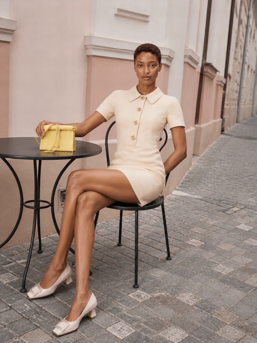 This pairing leans into a soft, tonal story, letting the buttercream Gucci mini and lemon Jacquemus bag do the work in a single clean gesture. The subtle gold hardware across both pieces reads cohesive rather than flashy, while the ivory Roger Vivier pumps keep the line polished and leggy for gallery evenings or city cocktails. Choosing the dress route over separates keeps the silhouette simple and architectural, which suits the bag’s structured, minimalist attitude best.