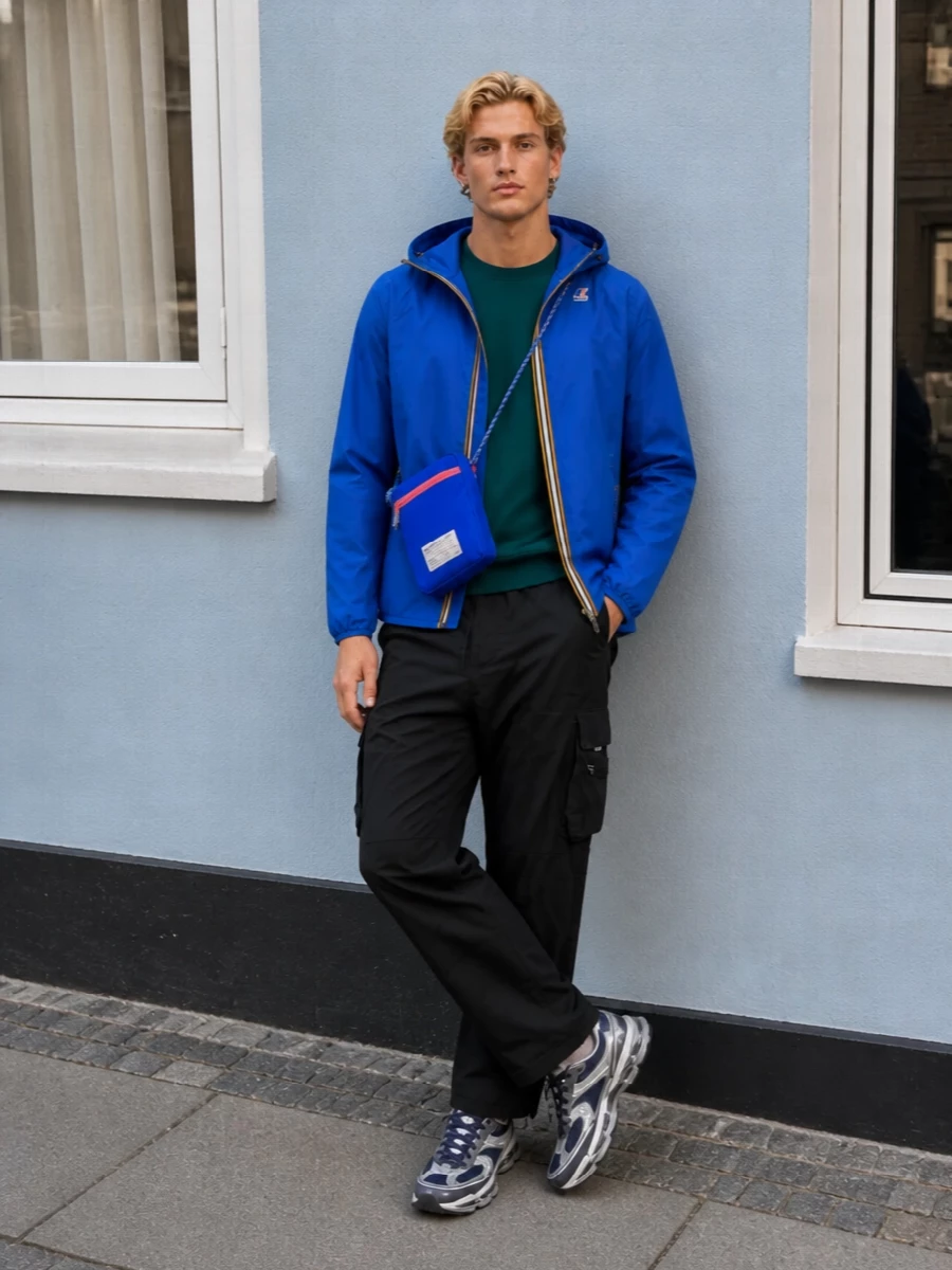 A fast, city-ready mix of technical layers, this outfit runs a bold royal blue shell over deep teal and black streetwear basics. Cargo detailing and trail-influenced sneakers keep the silhouette agile and utility-led, while the cobalt crossbody pulls the blues together with a confident hit of color.