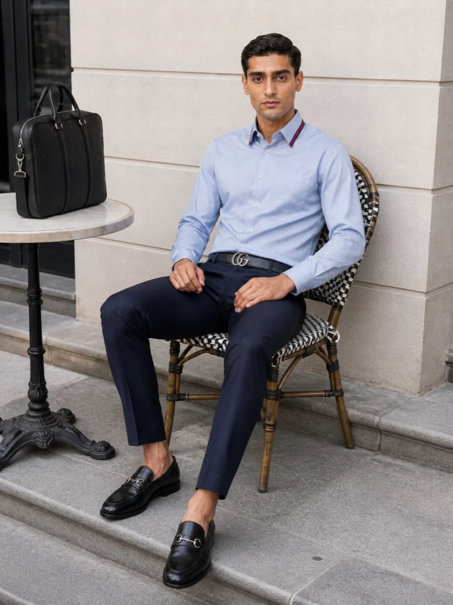 A pale blue contrast-collar shirt meets deep navy tailoring for a precise, modern office uniform that still reads relaxed enough for dinner. Black horsebit loafers, a slim GG belt and a structured briefcase keep the lines sharp and cohesive without distracting from the refined collar detail.